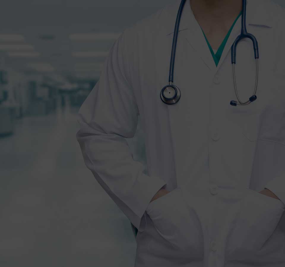 Doctor is standing with stethoscope and put her hands inside the pocket of hospital uniform